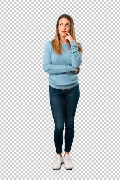 Blonde woman with blue shirt having doubts while looking up