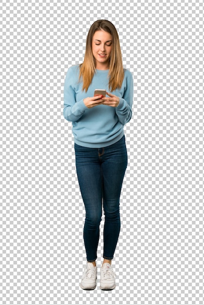 Donna bionda con la camicia blu inviando un messaggio con il cellulare