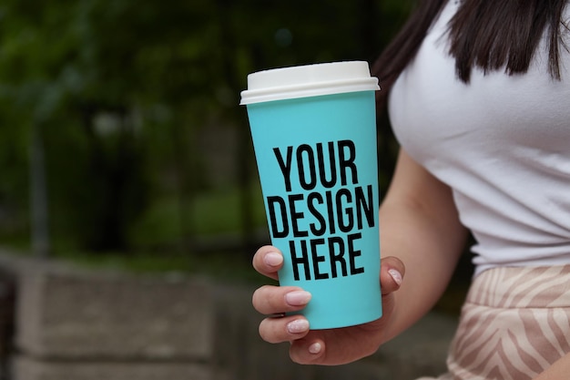 Mockup di tazza da caffè blu nelle mani di una ragazza psd di colore mutevole