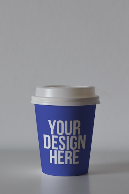 PSD tazza da caffè in carta di colore blu sul tavolo mockup design personalizzato colore mutevole primo piano