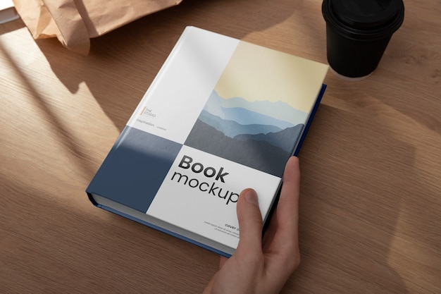 Book mock-up hand held by person