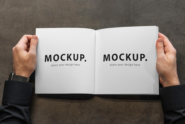 a book with a hand holding a book that says place your design here.