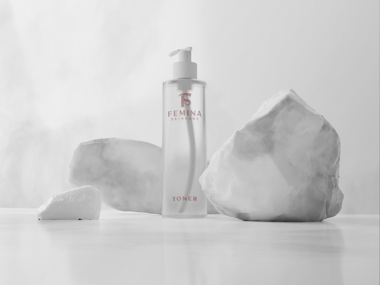 PSD a bottle of femina brand next to a pile of rocks.