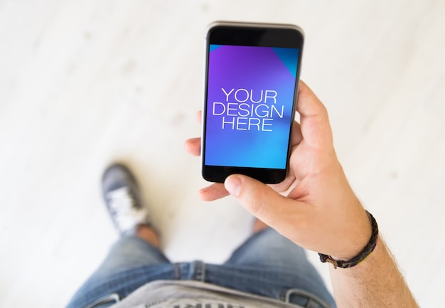 PSD bovenaanzicht van een man opknoping mobiele telefoon mock up
