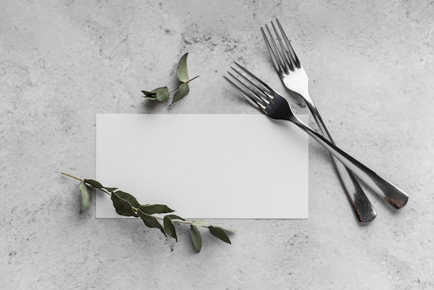 Bovenaanzicht van tafelopstelling met mock-up van het lentemenu en vorken