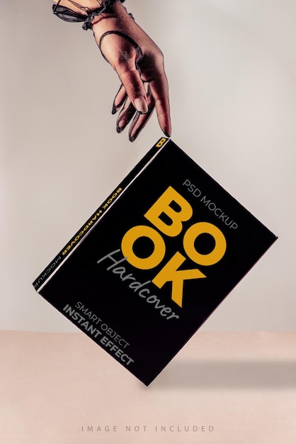 box or book cover on the beige background with hand in vintage gloves