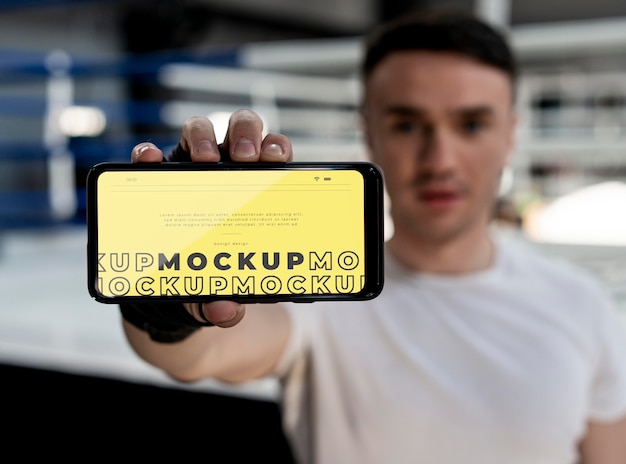Boxing athlete holding a mock-up phone