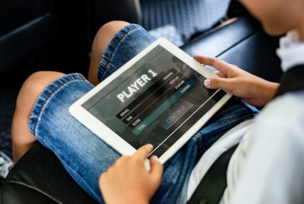 Boy playing on a digital tablet in the car