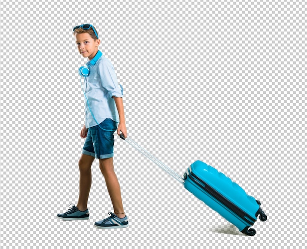 Boy with sunglasses and headphones traveling with his suitcase