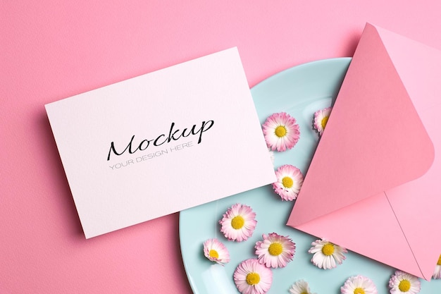 Bruiloft uitnodigingskaart mockup met roze envelop en madeliefjebloemen