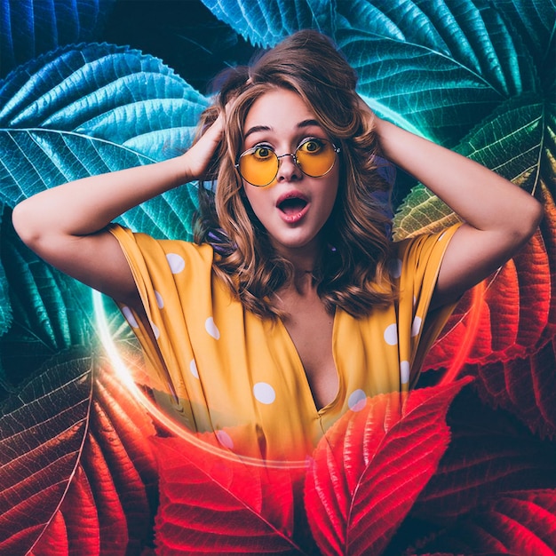 ブラッシュ効果写真色とりどりの葉に囲まれた黄色いメガネをかぶった驚いた女性
