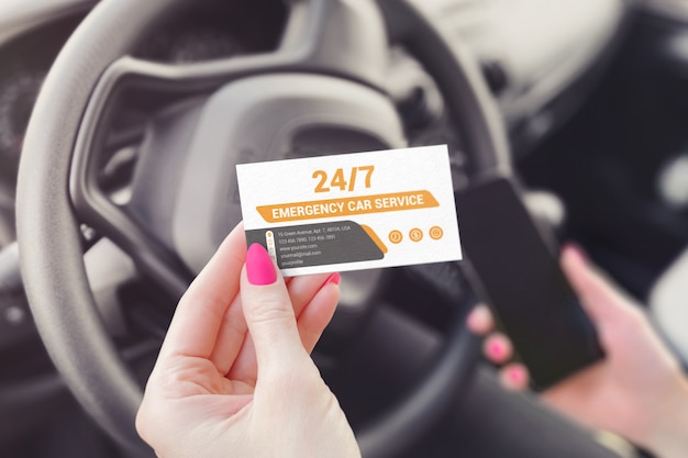 PSD business card in the hand of a girl sitting in a car mockup