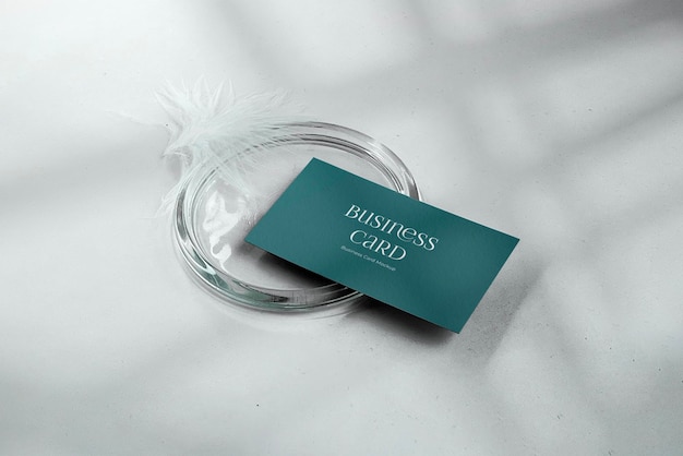 Business card mockup with feather and glass candlestick