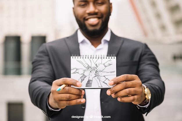 Business mockup with businessman showing notebook