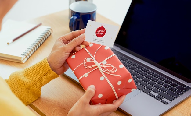 Donna d'affari con scatola regalo e biglietto di auguri sul tavolo dell'ufficio