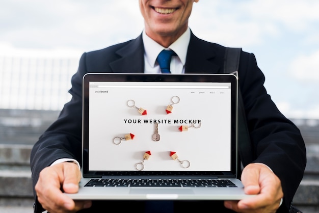 Businessman presenting laptop mockup