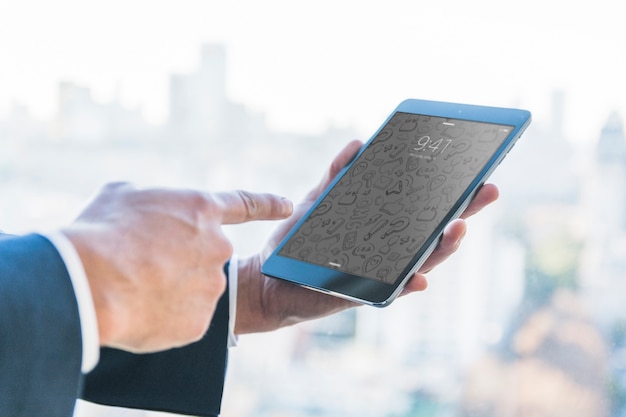 Businessman with finger at tablet in front of city skyline