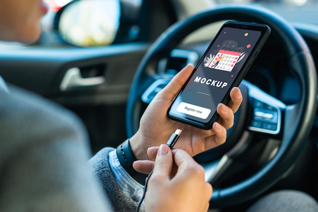 Businesswoman in car holding phone mockup