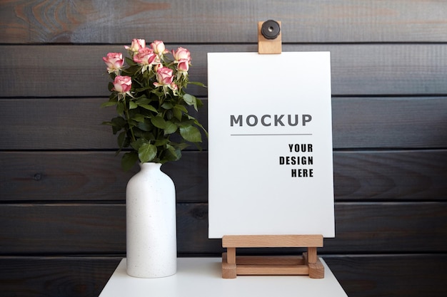 Canvas mockup on white table with vase of flowers