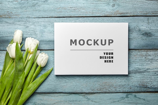 Canvas print mockup and white tulip flowers on light blue wooden surface flat lay