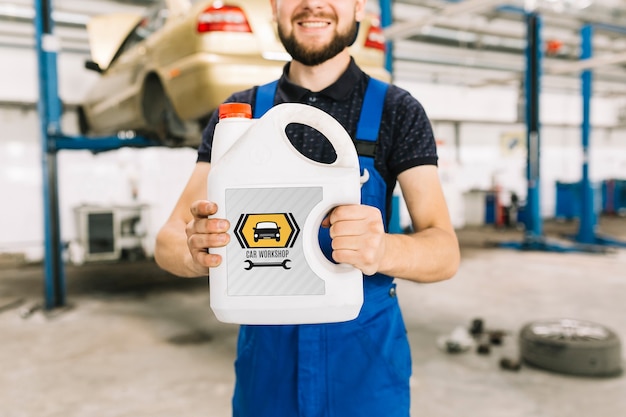 PSD car mechanic holding plastic can mockup