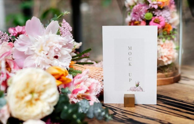 card mockup by bouquet of flowers on a wooden table