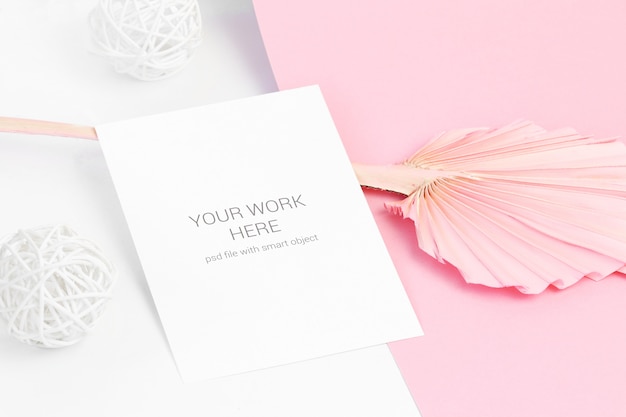 Mockup di carta su foglia rosa e palle di legno