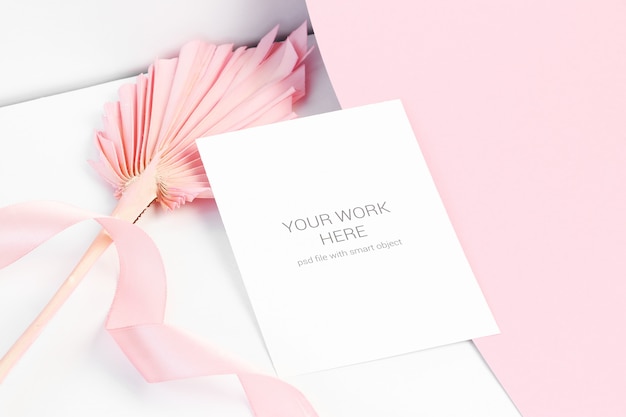 PSD mockup di carta sulla superficie rosa con foglia di palma