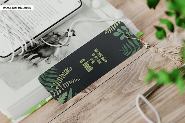 PSD cardboard bookmark with tassel near the book on the wooden table mockup