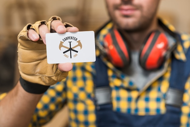 PSD carpenter holding business card mockup