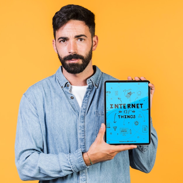 PSD casual young man holding a tablet mock up