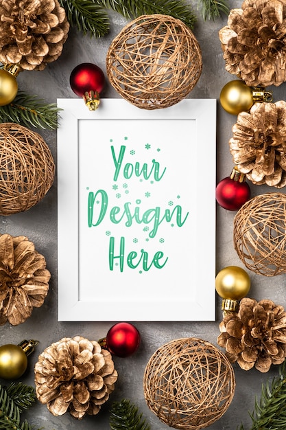 PSD christmas composition with empty picture frame. golden ornament, pine cones and fir needles decorations. mock up greetings card template