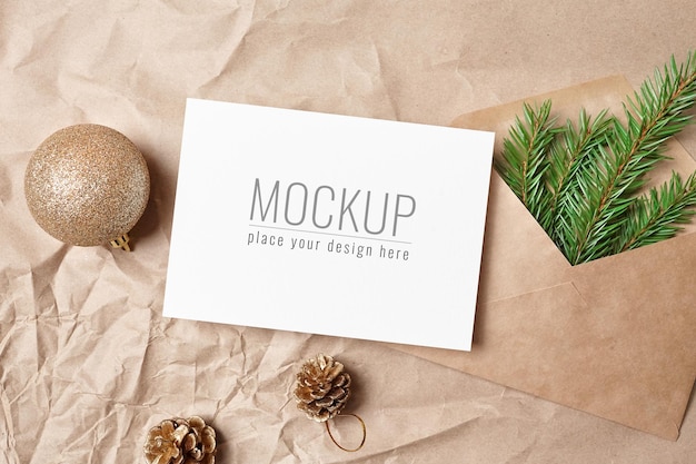 Christmas greeting card mockup with festive decorations and envelope with green fir tree branch