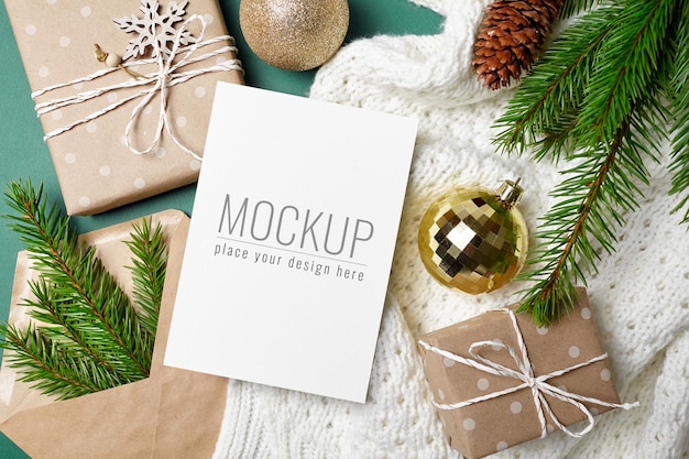 Christmas greeting card mockup with gift boxes, festive decorations and fir tree branches