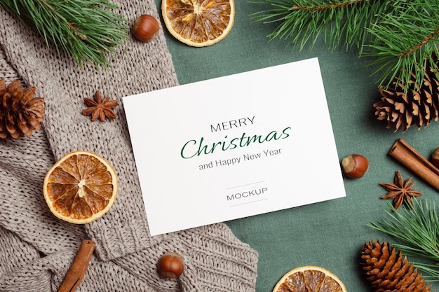 Christmas or New Year greeting card mockup with dry oranges, spices and pine tree branches with cones