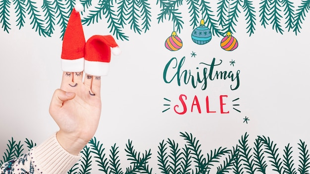 PSD christmas sale with santa's hat on a hand