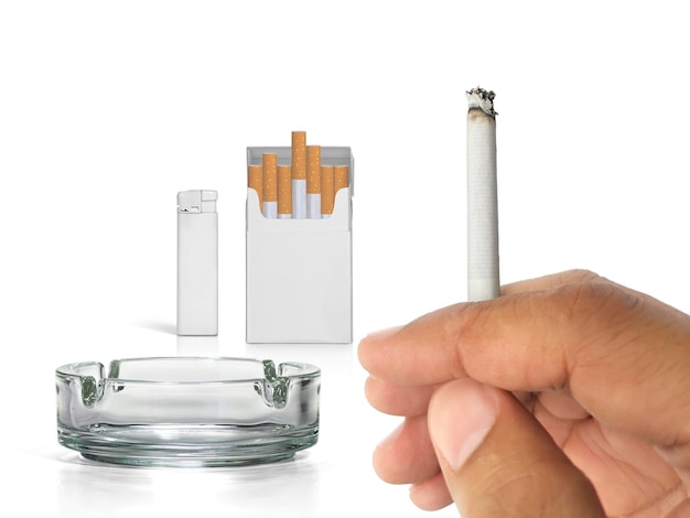 A cigarette in a hand cigarette pack ashtray and lighters on a transparent background