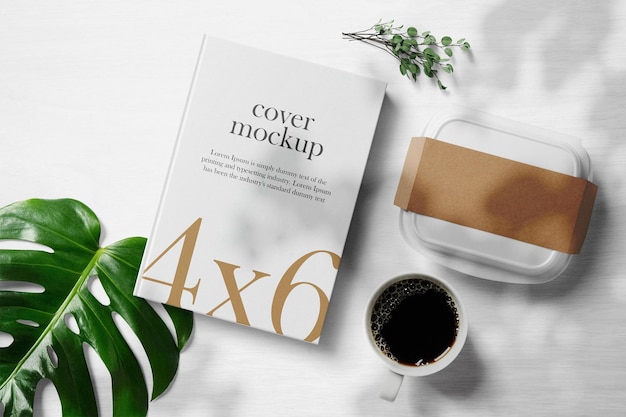 PSD clean minimal book 4x6 mockup on white desk background with big box coffee branches and leaves