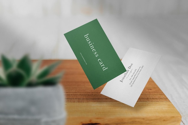 Clean minimal business card mockup floating on wooden plate with plant pot