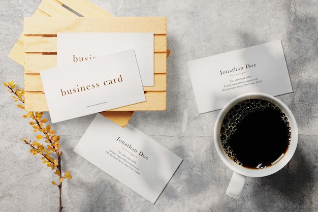 Clean minimal business card mockup on palette with cup and plant