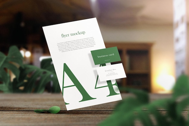 Clean minimal business card mockup on paper A4 floating on top wooden with leaves