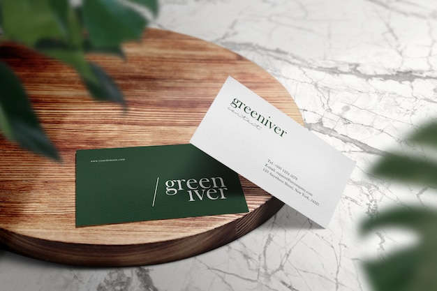 Clean minimal business card mockup on wood circle table and green leaves shadow.