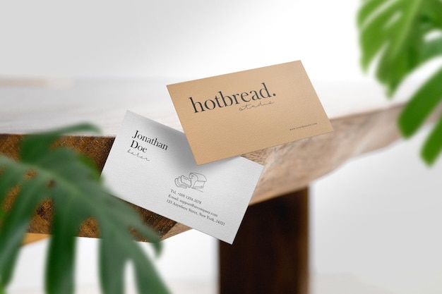 Clean minimal business card mockup wood table side with leaves