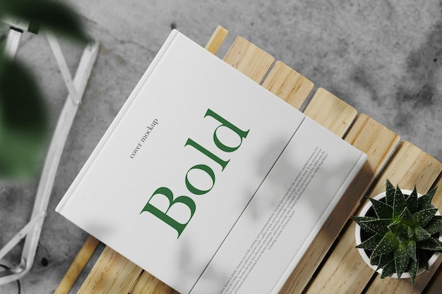 Clean minimal cover square book mockup on top wooden with plants background PSD file