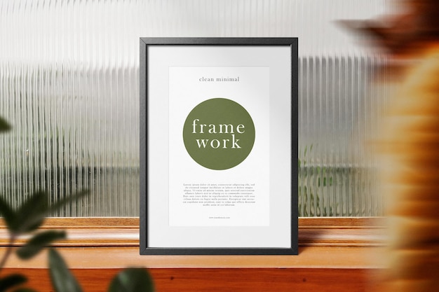 PSD clean minimal frame mockup standing on wooden top with leaves background psd file