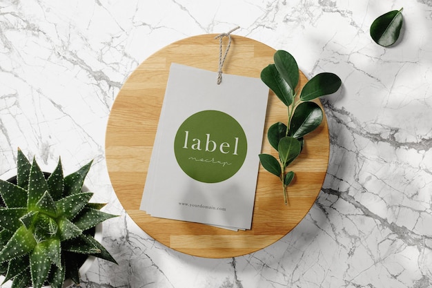 Clean minimal label with rope mockup on wooden plate with plant and leaves