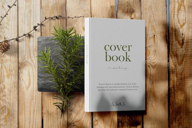 PSD clean minimal photo book 5.5x8.5 mockup on black stone with plant and stick background. psd file.