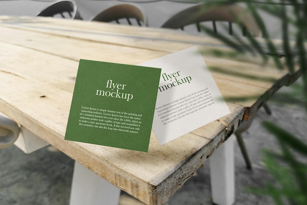 PSD clean minimal square card mockup floating on wooden top table with plant foreground