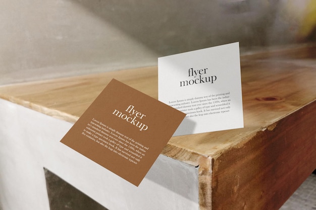 Clean minimal square flyer mockup floating on wooden bench. psd file.