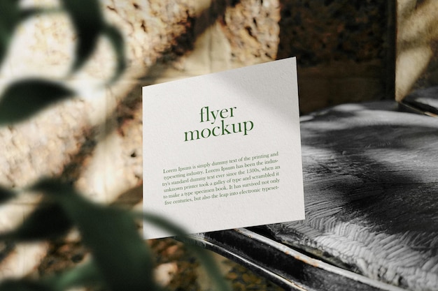 Clean minimal square flyer mockup floating on wooden bench with plant psd file